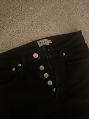 Jeans svarta  - Svarta jeans med knappar. Dessa är ifrån NAKD