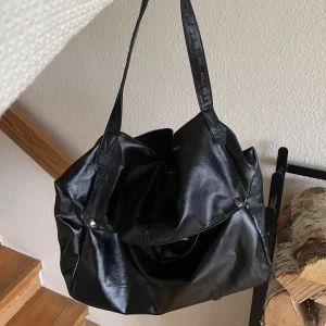 Svart handväska  - Väldigt rymlig! Det finns ett långt band med så man han ha den tvärs över kroppen! Älskar den men har dessvärre för många väskor💖