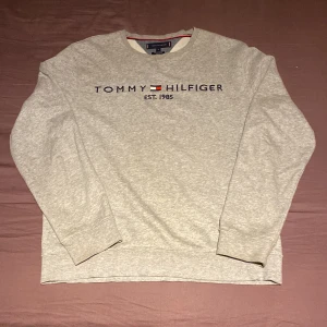 Tommy Hilfiger Sweatshirt Grå - Enkel grå Tommy Hilfiger sweatshirt. Inte använd på ett bra tag därför säljer jag den. Storlek: M (168-172) Skick: Använd men inga skador Dm för frågor eller fler bilder