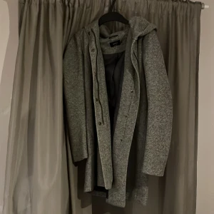 Kappa från Only - Grå kappa med luva från only. Storlek xs. Knappt använd. Säljer på grund av att den inte passar längre. 