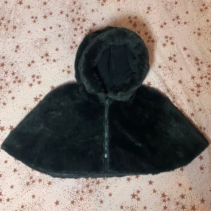 Sagolik CAPE / LÖSLUVA i fuskpäls!  - Cape för enbart axlar / lösluva, i fuskpäls.  Fint skick. Strl S-M.  Finns i Stockholm, möts upp eller skickas mot porto. ✨ Billigare vid snabb smidig affär! 