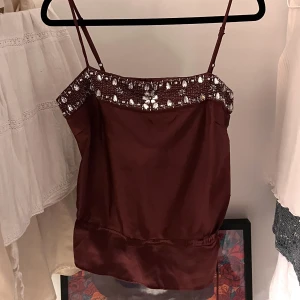 Y2k linne strl eu 40 - Storlek eu 40 lila/vinrött linne. Köpt på Humana för 220kr. Säljer då den är alldeles för liten i brösten för mig-(har E/D kupa), men äääääälskar modellen samt färg och paljetterna😭💓