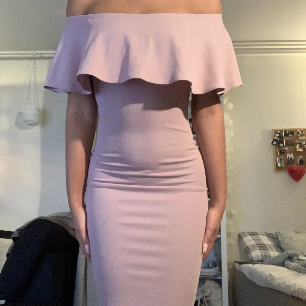 Puderrosa bodycon klänning. Off the shoulder med en större volang. Längd går förbi knärna. Från Nelly i storlek xs men är stretchig . Klänningar.