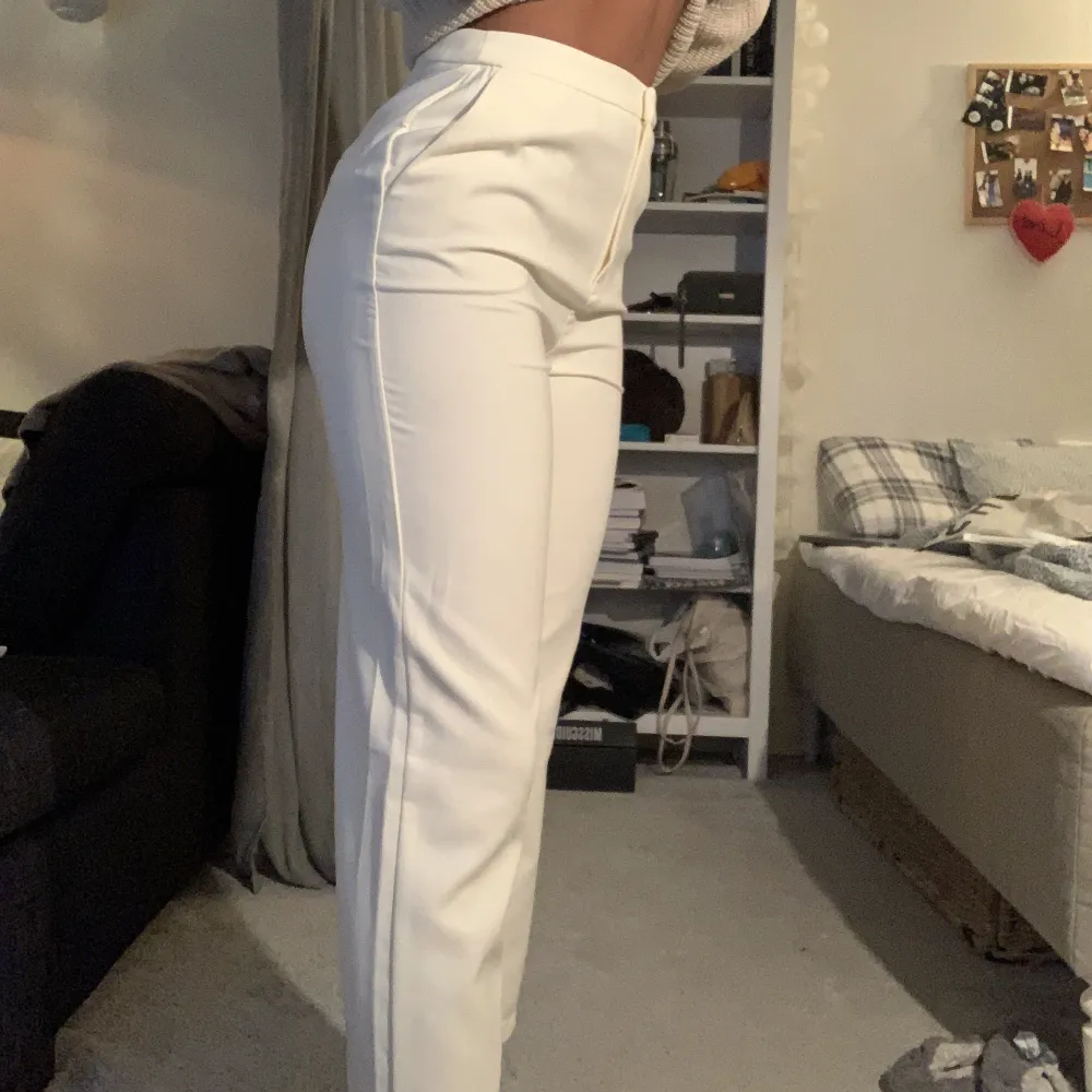 Vita högmidjade kostymbyxor. Lite croppade på längden. Aldrig använd och har fortfarande etiketten på. Köpta på NA-KD i storlek 36. Jeans & Byxor.
