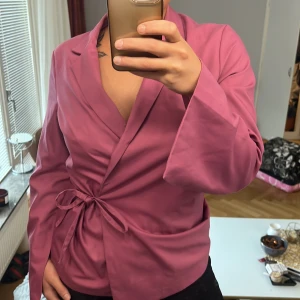 Kavaj med knytning - Rosa fin kavaj med knytning.  Sitter väldigt fint på och man väljer själv hur hårt den ska sitta på. 