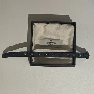 Valentino Armband - Ett marinblått valentino armband med svarta nitar! Skick: 8/10, inget mer än tecken på användning vid hålen. Nypris: 2200kr (om jag inte missminner). Kvitto finns, köpt på NK, all original utrusning finns kvar. Skriv privat vid frågor eller funderingar!