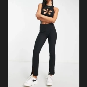 Pull&Bear svarta utsvängda byxor med slits - Storlek XS endast provade, hög midja och stretch, kostym/figursydda byxor