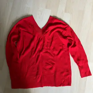 Röd stickad tröja med V-ringning fram och bak