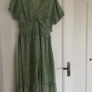 Grön klänning - Köpt från asos storlek 12 = 40/42 Jättefin klänning som är använd vid några tillfällen. Lång i runt material med inbyggd underklänning.    Frakten står köparen för. Betalning via swish före eller vid tillfälle när varas skickas