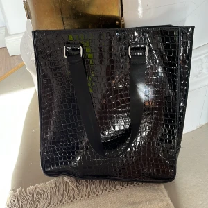 Svart väska - En hyfsat stor och rymlig väska i ”ormmönstrad” struktur. Väskan är inte mer än 2 år gammal och är i ett bra skick 🖤