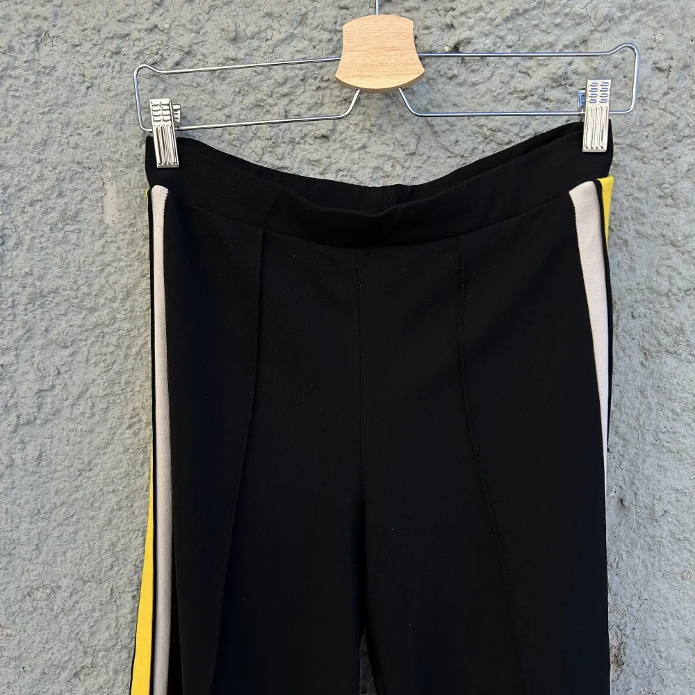 Svarta byxor med gula revärer. Bekväm och stretchig trikå. 96% polyester, 4% elastan. Älskar dessa byxor men upplever attt de är för korta för mig (176cm med långa ben). Swish is queen 🌞🌻. Jeans & Byxor.