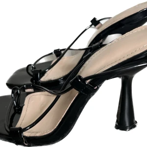 Svarta klackar med långa band!  - Svarta glansiga klackar med långa band som går att knyta som man själv vill! Använda och slitna på själva klacken där den nuddar marken. Annars fint skick! Säljer även massa andra klackar, kolla in min profil!