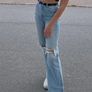 Jeans från Zara  - Jeans Wide Leg Full Length- ljusblå med slitningar. Jättefina jeans i fint skick, dock har vissa av de vita slitningarna har gått av. Nypris 399kr. Säljer då de inte längre kommer till användning 💙  
