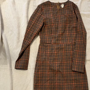 Rutig klänning  - En långärmad kort rutig klänning som sitter superfint på. Klänningen är i bra skick! 