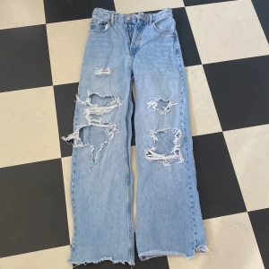 Jeans från Zara strl 34 - Jeans med hög midja och hål, från Zara. Strl 34 men är något kapade på längden. 