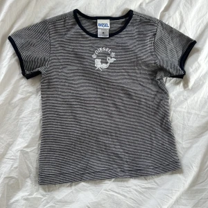 Diesel t-shirt  - Jättesöt liten t-shirt från diesel, jättebra kvalitet. Se bild 3, påsytt under armhålorna för större ärmar som innan var väldigt tajta. Så snygg till lågmidjade jeans! Hör av er vid frågor!