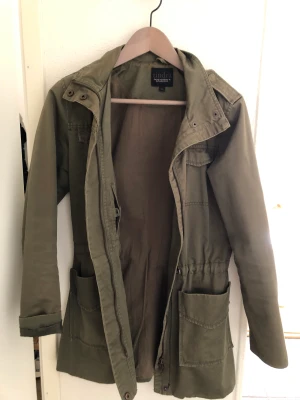Grön jacka - Vintage jacka. Man kan spänna i midjan. Finns ej luva
