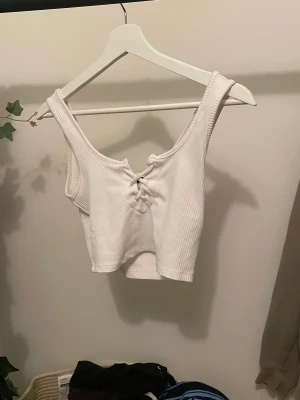 Topp - Jättefint vitt linne med snören på bröstet. Från Gina tricot, knappt använd och i nyskick. 