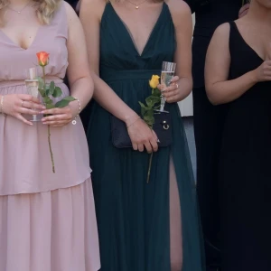 Grön långklänning - Mörkgrön långklänning från Lulus. Endast använd en gång så är i väldigt fint skick. Går hela vägen till golvet på mig som är 180cm, se sista bilden. Har två slitsar framtill. Hör gärna av er om ni vill ha fler bilder privat ☺️