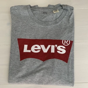 T-shirt  - Snygg grå T-shirt med rött tryck från Levi’s i fint skick! 