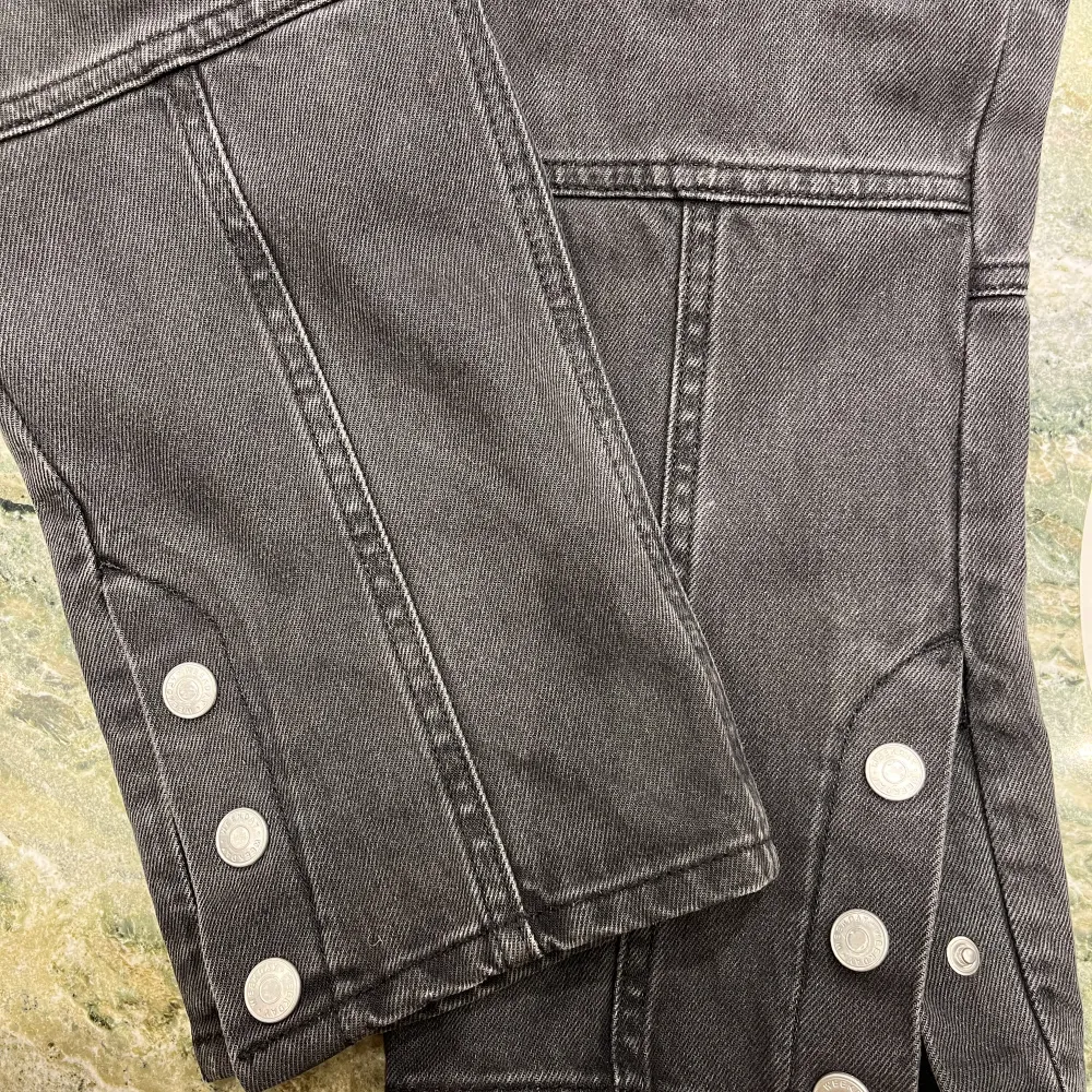 Unika Svarta jeans från Weekday med lappteknik och knappar nedtill som går att knäppa och knäppa upp till en mer bootcut modell. Sitter supersnyggt! Bra skick. Storlek 36. Skriv för fler bilder!. Jeans & Byxor.
