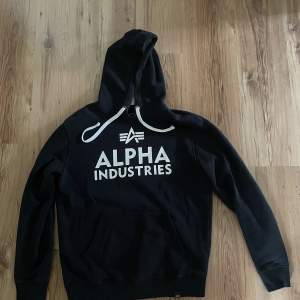 En svart HOODIE från Alpha Industries i storlek M 