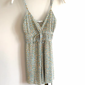 Jumpsuit med blommor  - Supersöt jumpsuit/byxdress ifrån PULL&BEAR. Obs, färgerna är pastell, kameran visar inte riktigt den egentliga färgen :) 