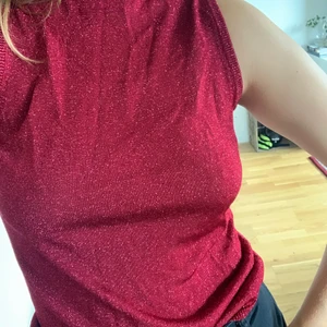 Glittrig, röd, polo - En ärmlös polotröja i ”stickat” material, köpt secondhand. Glittrar jättefint och är inte genomskinlig alls. Jättefint skick. Skickas med frimärke om inte annat önskas (kostar extra). Är normalt m/38 och toppen passar s-L beroende på önskad passform.  Pris kan diskuteras 