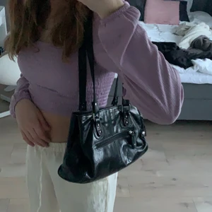 svart väska - En super fin axelväska som går att få plats med mycket i! Den är verkligen super rymlig med många fack. Väskan är en superfin touch till sin outfit! (budgivning om många är intresserade).