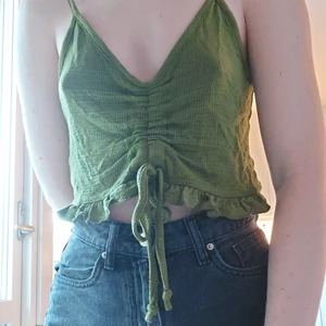 Grön top med knytning  - En jättefin mörkgrön top från Bikbok i storlek XS. Endast använd ett fåtal gånger, alltså i väldigt fint skick! Väldigt luftigt och skönt till sommaren. Kontakat mig gärna vid frågor!😊