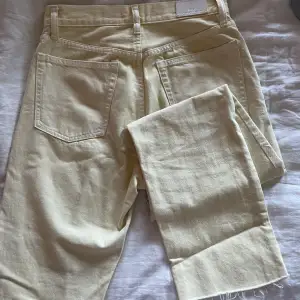 Ljusgula jeans från Mango med slitningar längst ner 
