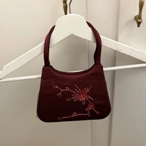 Liten handväska  - En liten handväska, oanvänd, väldigt bra skick, cirka 15 cm lång, fina detaljer  