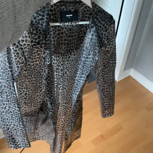 Regnjacka  - Regnjacka som är leopard färgad. Genomskinlig, använt en gång. Säljer för 100 kr