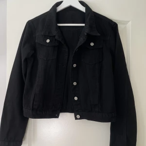 Svart jeansjacka - Storlek M, normal i storlek Knappar, två bröstfickor. Kom aldrig till användning, därmed utan anmärkning.  150 kr