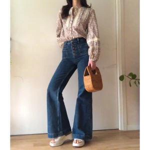 & Other Stories blus - Retrostil på denna småblommiga blus från & Other Stories! Färgerna går i beige/grönt/orange/lila, och blusen har söta detaljer i virkad spets. Ballong/puffärmar, så sjukt snygg att jag är osäker på om jag vill sälja.