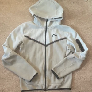Beige Nike Tech hoodie XS - Köpt från jd för länge sen , har använt den, finns inte att köpa i affär längre, meet up i sthlm
