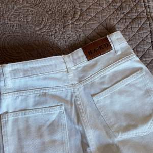 Jag säljer dessa högmidjade vita jeans från NAKD. Använda en gång, storlek 32, passformen är rak men lite bredare ner mot benen.