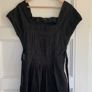 Svart klänning  - En svart klänning med band och lite detaljer vid bröstet. Från InWear i storlek 36. Oanvänd. 130 kr + frakt ( cirka 50kr)