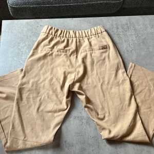 Mjuka kostymbyxor xs - Beiga mjukisar i kostymbyx-modell. Aldrig använda