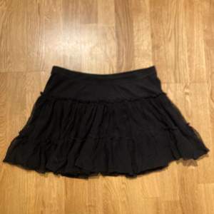 En svart kjol som är lågmidjade och puffig.