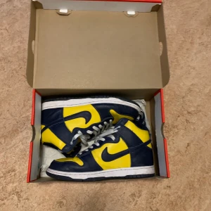 Nike dunk high Michigan  - Dunks i bra använt skick extra navy blue snören följer med, Orginalbox finns de är i storlek 42, kolla mina andra annonser, köpte står för frakt  vänligen Arvid 