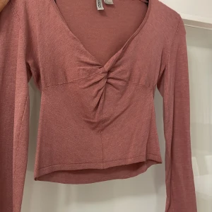 Rosa topp - Rosa topp från H&M. Mjukt material och croppad med en liten fin knytning där fram<3 aldrig använd