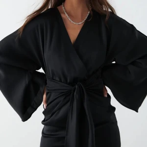 Omlottklänning i Satin - Säljer nu denna jättefina omlottklänning i satin från Gina Tricot. Den är helt oanvänd och prislappen sitter kvar. Passar en M bra också. Glömde bort den i garderoben och nu passar den mig tyvärr inte längre. Skriv för fler bilder 💗