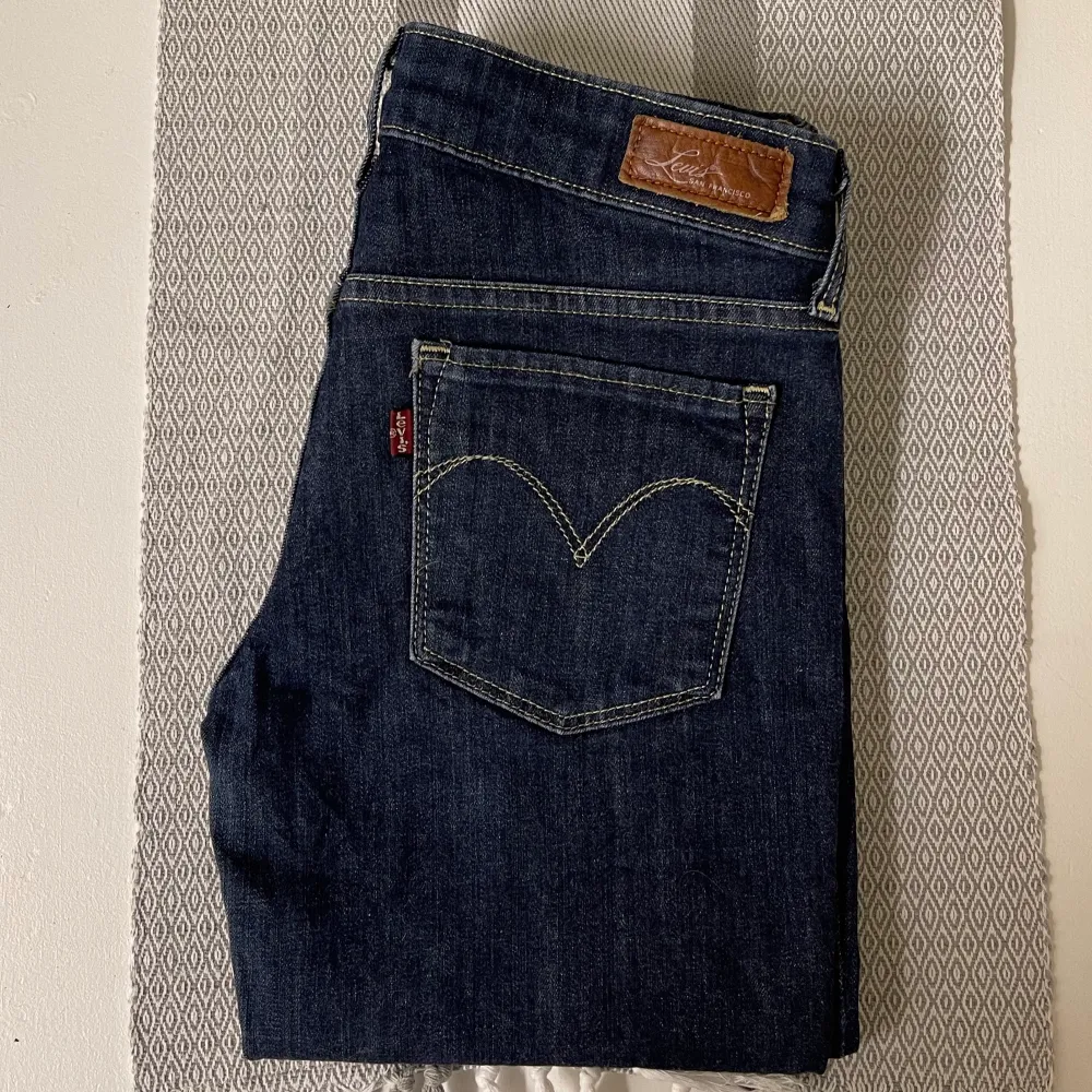 Säljer ett par low waist jeans från Levi’s. Storlek 25/32. Midjemått 35cm (tvärs över) och innerbenslängd 78cm. Byxorna är i fint skick! Fin mörkblå denim färg ☺️material: 91% bomull 8% polyesterfiber 1% elastan. Stretchiga och sköna på 🥰 . Jeans & Byxor.