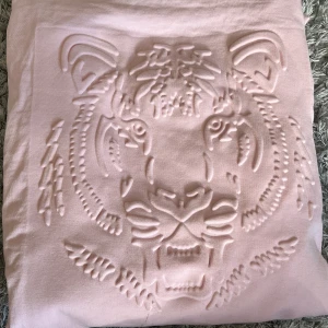 Tiger Sweatshirt  - Ljusrosa sweatshirt med tiger motiv. Motivet står ut från tröjan. Storlek 170. Inte använd många gånger då jag blir aningens blek😅. Jättefint skick!!