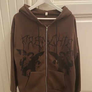 Brun zip up hoodie - Brun zip up hoodie från shein, med svart märke på framsidan! Säljer för att jag inte använder! Köpare står för frakt💫(49kr frakt)