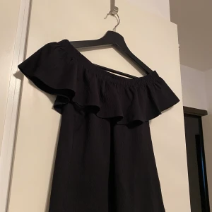 Offshoulder topp från GinaTricot - En svart offshoulder topp från GinaTricot med volanger framtill. Använd ett fåtal gånger. Toppen går att ha till flera olika typer av outfits. 🖤