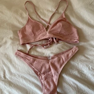 Helt ny rosa bikini strl M, passar S - Helt ny rosa bikini i storlek M, passar även S! Aldrig använda uttagbara pads, korsningsdetaljer i ryggen, justerbar, intimskydd kvar! Frakt 52💕