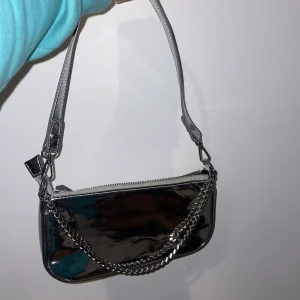Silver Väska - Säljer min silver väska från Gina Trickot. Inga defekter eller repor då jag knappt använt den. Pris: 99 kr