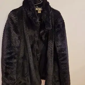 En fake fur kappa, svart från H&M , fickor på sidan , sitter väldigt snyggt på kroppen! 